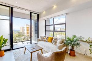 a living room with a couch and a table at Ocean-view condo with infinity pool, rooftop lounge, & private balcony in Bucerías