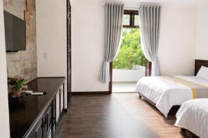 a bedroom with a bed and a large window at Cherry Villa in Hue