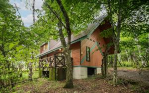 a wooden cabin in the woods with trees at Wan Wan Paradise Tateshina in Tateshina