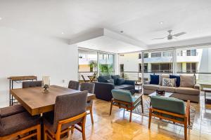 a living room with a couch and a table and chairs at Stylish condo with covered balcony, pool & pool tables in Nuevo Vallarta