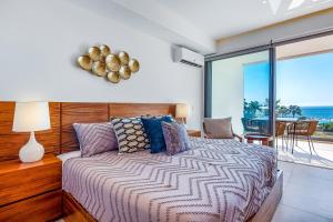 a bedroom with a bed with a view of the ocean at Oceanfront condo with a full kitchen, pool, & beach access in Nuevo Vallarta +16 photos