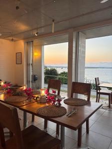 a dining room with a table and a view of the ocean at 413 Hamahiga Hotel＆Cafe in Uruma