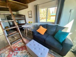 a living room with a blue couch and a bunk bed at Blue Moose Cabin at Moose Tracks Lodging in Kenai +10 photos