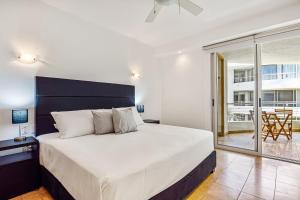 a bedroom with a large bed and a balcony at Stylish condo with covered balcony, pool & pool tables in Nuevo Vallarta +37 photos