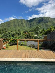a wooden deck with a view of the mountains at L'échappée de Bras Long in Entre-Deux