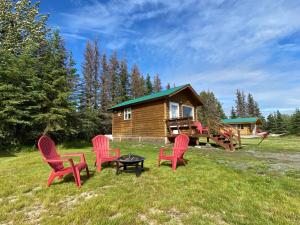 a group of red chairs in front of a cabin at Blue Moose Cabin at Moose Tracks Lodging in Kenai