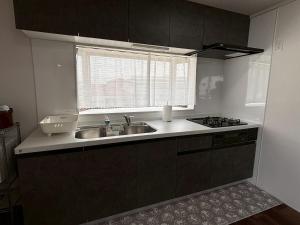 a kitchen with a sink and a window at 京阪楽宿 in Kadoma +19 photos