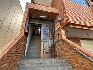 a set of stairs leading to a building with a door at 京阪楽宿 in Kadoma