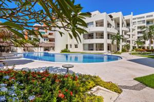 a large apartment building with a large swimming pool at Stylish condo with covered balcony, pool & pool tables in Nuevo Vallarta