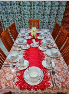 a table with plates and cups on a red table cloth at Dream Big Accommodation in Apia