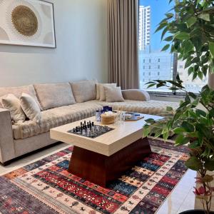 a living room with a couch and chess board on a table at Ocean Bliss Jacuzzi - Sea View- Check-in in Al Khobar +2 photos