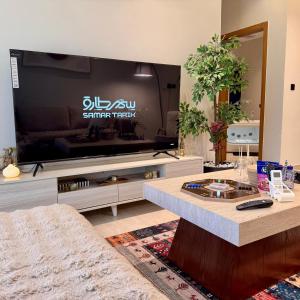 a living room with a large flat screen tv at Ocean Bliss Jacuzzi - Sea View- Check-in in Al Khobar