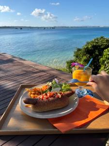 a plate of food with a hot dog and a drink at 413 Hamahiga Hotel＆Cafe in Uruma +21 photos