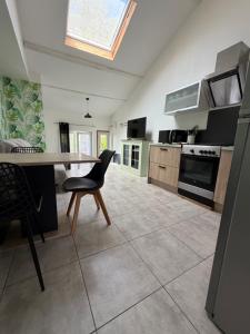 a kitchen with a table and a chair in it at Gite Matilon, 5 min Eugénie les Bains in Buanes