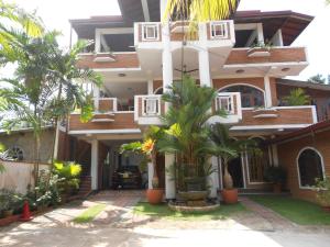 uma casa com palmeiras em frente em Melvila em Colombo