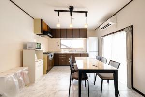 a kitchen and dining room with a table and chairs at 六鶴亭-ビーチ徒歩8分,スーパー徒歩2分,駅徒歩12分 in Manazuru