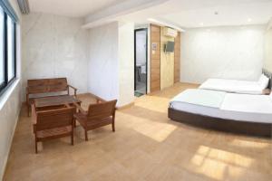 a bedroom with a bed and a table and chairs at Tom Hotel Huế near Phu Bai Airport in Hue +16 photos