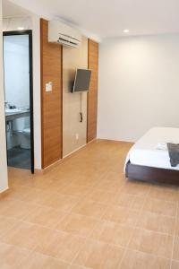 a bedroom with a bed and a bathroom with a sink at Tom Hotel Huế near Phu Bai Airport in Hue