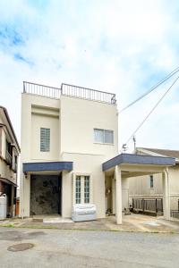 a white house with a garage at 六鶴亭-ビーチ徒歩8分,スーパー徒歩2分,駅徒歩12分 in Manazuru +70 photos