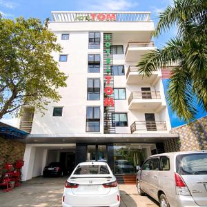 two cars parked in front of a hotel at Tom Hotel Huế near Phu Bai Airport in Hue