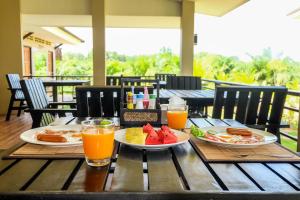 a table with two plates of food and orange juice at The Oasis Khaolak Resort - SHA Plus in Khao Lak