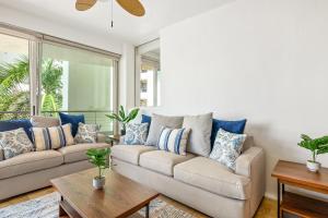 a living room with a couch with blue and white pillows at Ocean-view condo with resort pool & sundeck in Nuevo Vallarta +29 photos