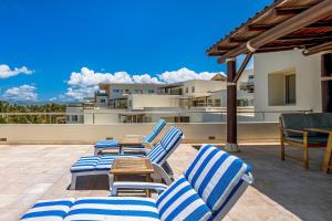 a group of chairs and a table on a patio at Ocean-view condo with private rooftop pool, terrace, & resort-style pool in Nuevo Vallarta