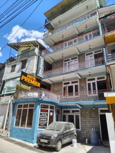 a car parked in front of a building at Hotel Premier in Manāli +11 photos