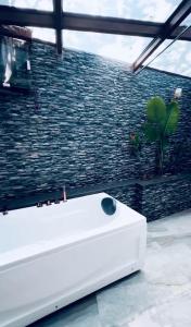 a white tub in a room with a brick wall at The S - Luxurious Stays in Mahabaleshwar +23 photos