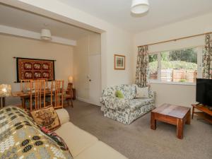 a living room with a couch and a table at Gardener's Cottage in Llandrindod Wells
