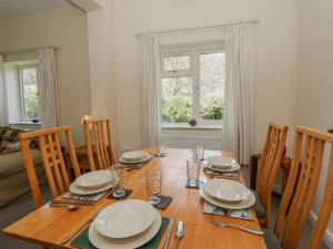 a dining room table with chairs and a wooden table with plates at Gardener's Cottage in Llandrindod Wells +23 photos