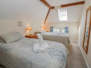 a bedroom with two beds with towels on them at Gardener's Cottage in Llandrindod Wells