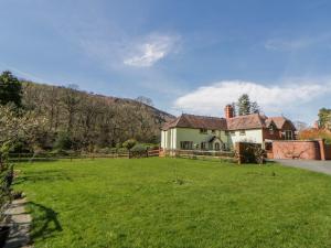 a house in a field with a grass yard at Gardener's Cottage in Llandrindod Wells