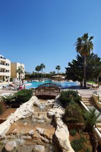 a swimming pool with a waterfall in a resort at Panareti Coral Bay Villas in Coral Bay
