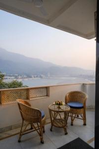 a balcony with two chairs and a table with a view at Luxury 2 Bedroom's Appartment in Rishīkesh +14 photos