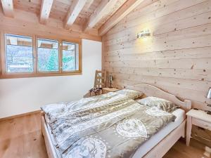a bed in a room with a wooden wall at Elevate in Ovronnaz