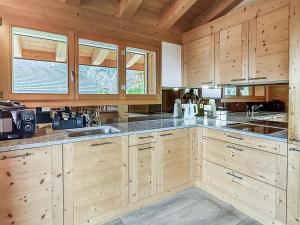 a large kitchen with wooden cabinets and counters at Elevate in Ovronnaz