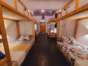 a room with three bunk beds and a hallway at FMS Rooms & Hostel in Arugam Bay