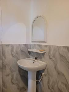 a bathroom with a white sink and a mirror at FMS Rooms & Hostel in Arugam Bay