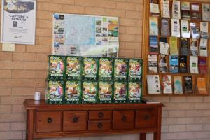 a bunch of books sitting on a wooden dresser at Golden Chain Aalana Motor Inn in Cowra +19 photos