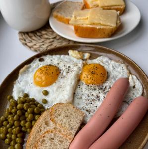 a plate of eggs and bread with peas and cheese at Karakol Aksuu guest house in Teploklyuchinskoye