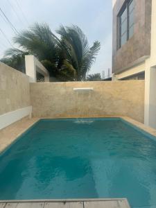 a swimming pool in front of a building at Hostel La Catalina Plus - frente al mar in Cartagena de Indias