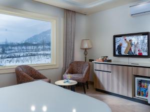 a hotel room with a bed and a tv at Faiz Resort Pahalgam in Pahalgām