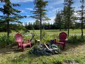 two chairs sitting next to a camp fire at Rustic Moose Cabin at Moose Tracks Lodging in Kenai