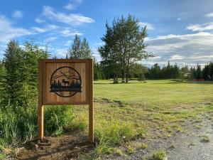 a wooden sign in the middle of a field at Rustic Moose Cabin at Moose Tracks Lodging in Kenai