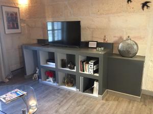 a entertainment center with a television on top of it at Appartements "La Chambre D'Ami" in Arles
