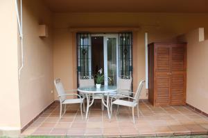 un patio con mesa y sillas en un porche en Apartamento Vespasiano, en Chiclana de la Frontera