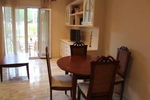 a dining room with a wooden table and chairs at Apartamento Vespasiano in Chiclana de la Frontera