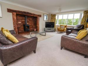 a living room with two couches and a fireplace at Manor Wood in Coddington