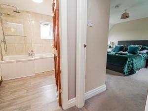 a bedroom with a bed and a bath tub and a bathroom at Manor Wood in Coddington +54 photos
